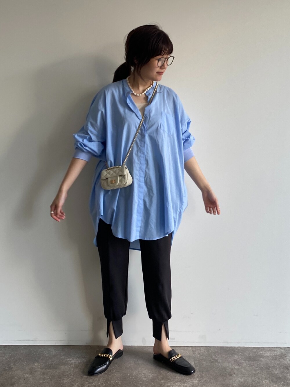 ホワイト系のショルダーバッグ、ブルー系のシャツ/ブラウス、ブラック系のその他パンツを着用したレディースの春コーディネートの3枚目の写真