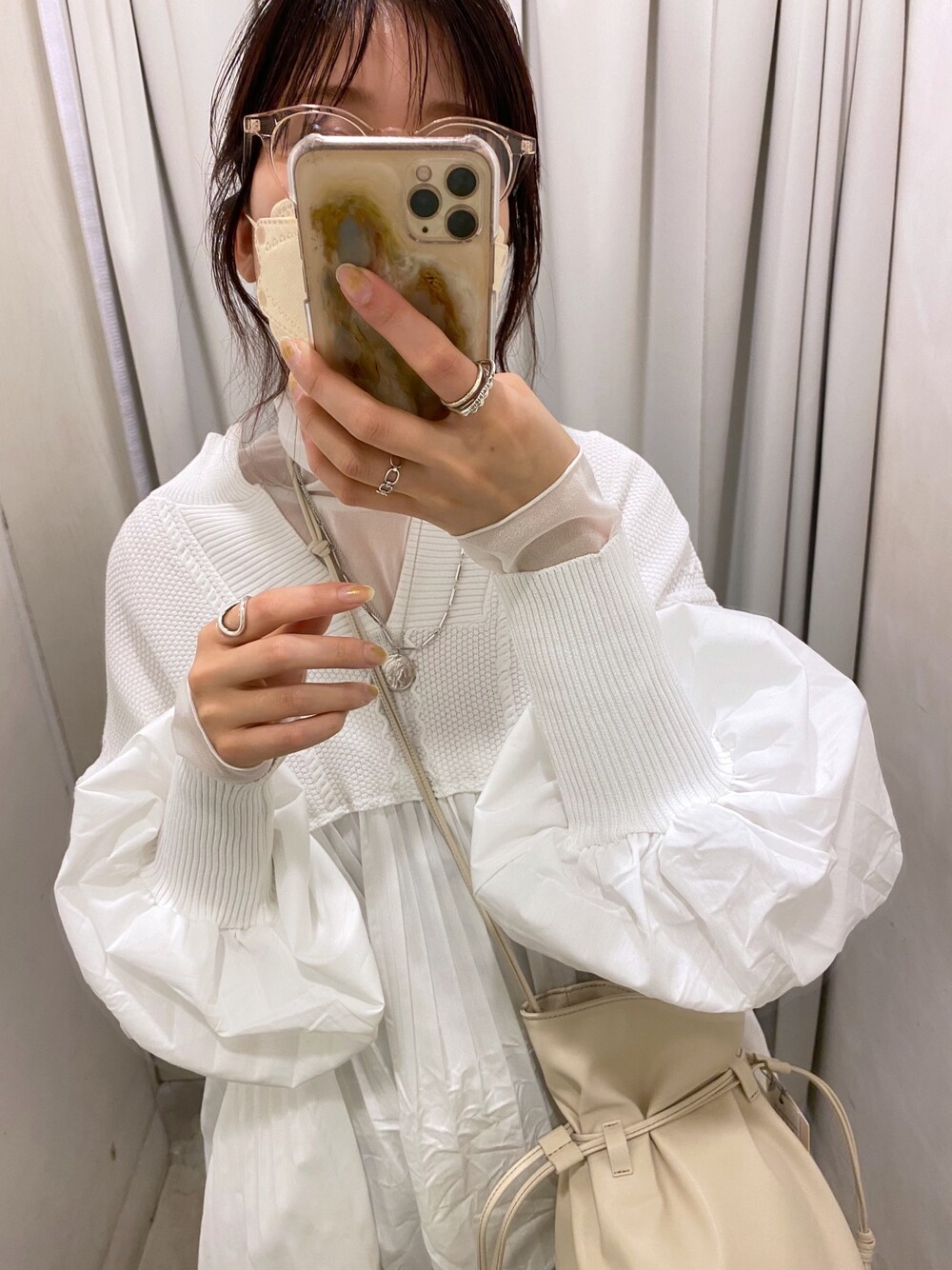 ホワイト系のTシャツ/カットソー、ベージュ系のステンカラーコート、ホワイト系のニット/セーターを着用したレディースの冬コーディネートの4枚目の写真