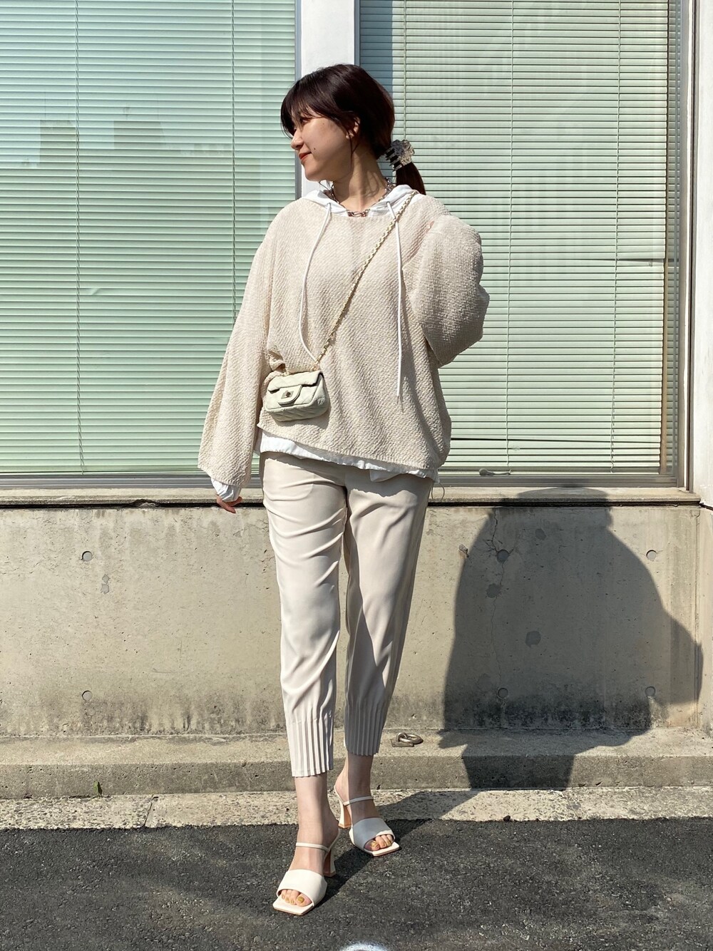ホワイト系のニット/セーター、ホワイト系のシャツ/ブラウス、ベージュ系のその他パンツを着用したレディースの春コーディネートの5枚目の写真