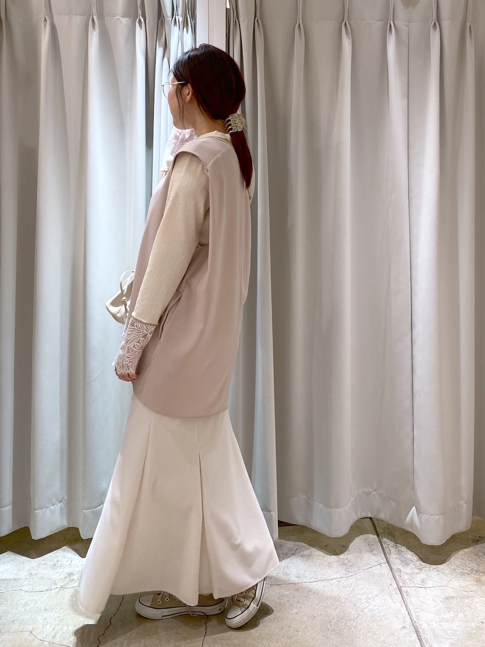 ベージュ系のベスト、ホワイト系のTシャツ/カットソー、ホワイト系のスカートを着用したレディースの春コーディネートの2枚目の写真