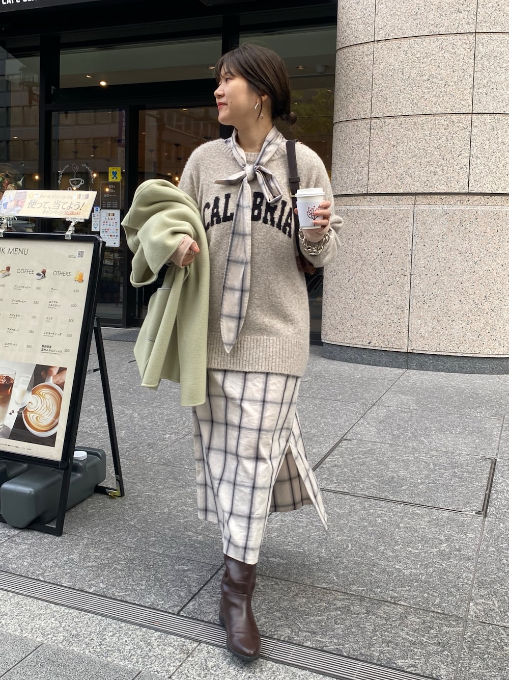 ホワイト系のワンピース、ホワイト系のニット/セーター、ブラウン系のブーツを着用したレディースの冬コーディネートの1枚目の写真