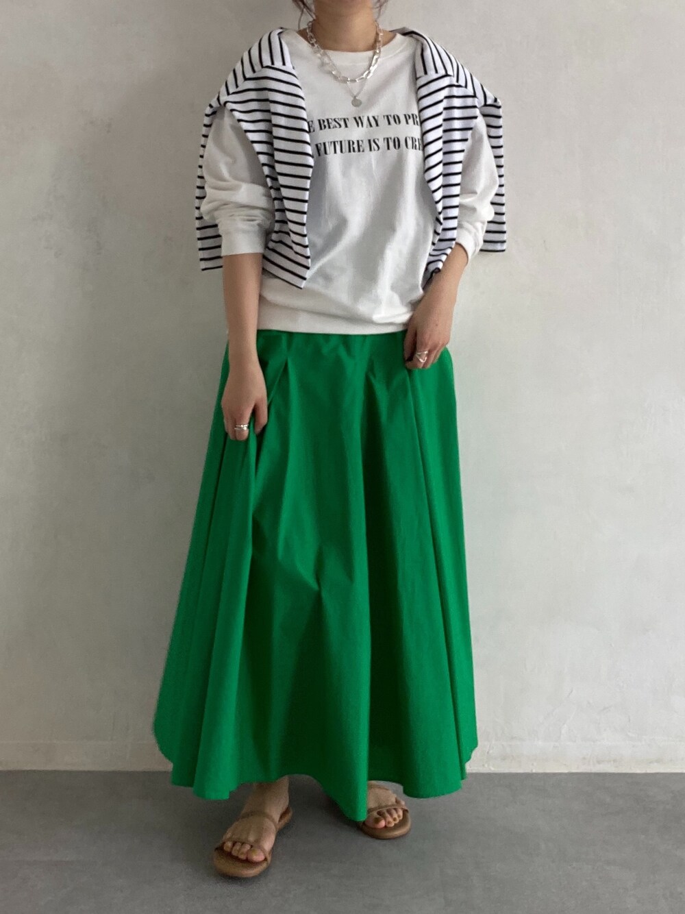 ホワイト系のTシャツ/カットソー、ホワイト系のTシャツ/カットソー、グリーン系のスカートを着用したレディースの春コーディネートの2枚目の写真