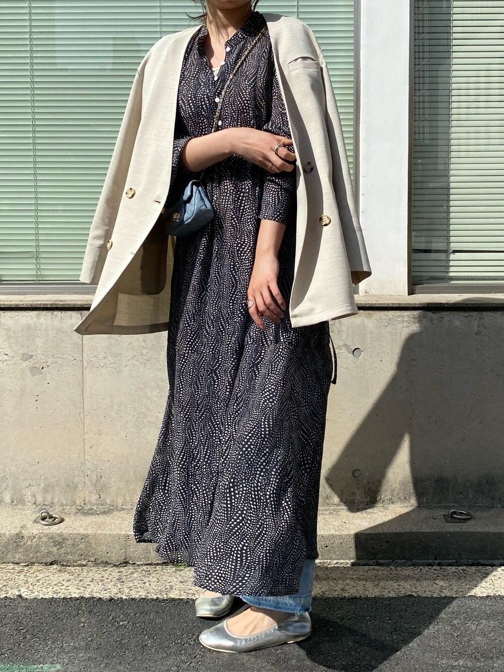 ベージュ系のノーカラージャケット、ブルー系のショルダーバッグ、ホワイト系のワンピースを着用したレディースの春コーディネートの5枚目の写真