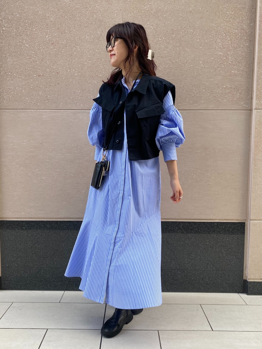 その他のベスト、ブルー系のワンピース、ブラック系のショルダーバッグを着用したレディースの冬コーディネートの3枚目の写真