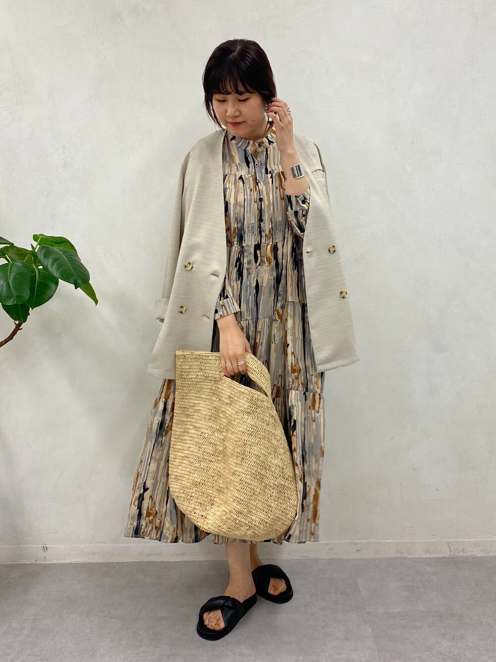 ブラウン系のワンピース、ベージュ系のノーカラージャケット、シルバー系のブレスレットを着用したレディースの春コーディネートの3枚目の写真