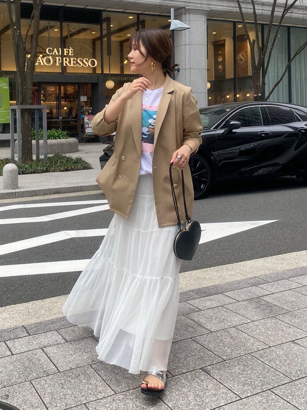 イエロー系のテーラードジャケット、ホワイト系のTシャツ/カットソー、ホワイト系のスカートを着用したレディースの春コーディネートの1枚目の写真
