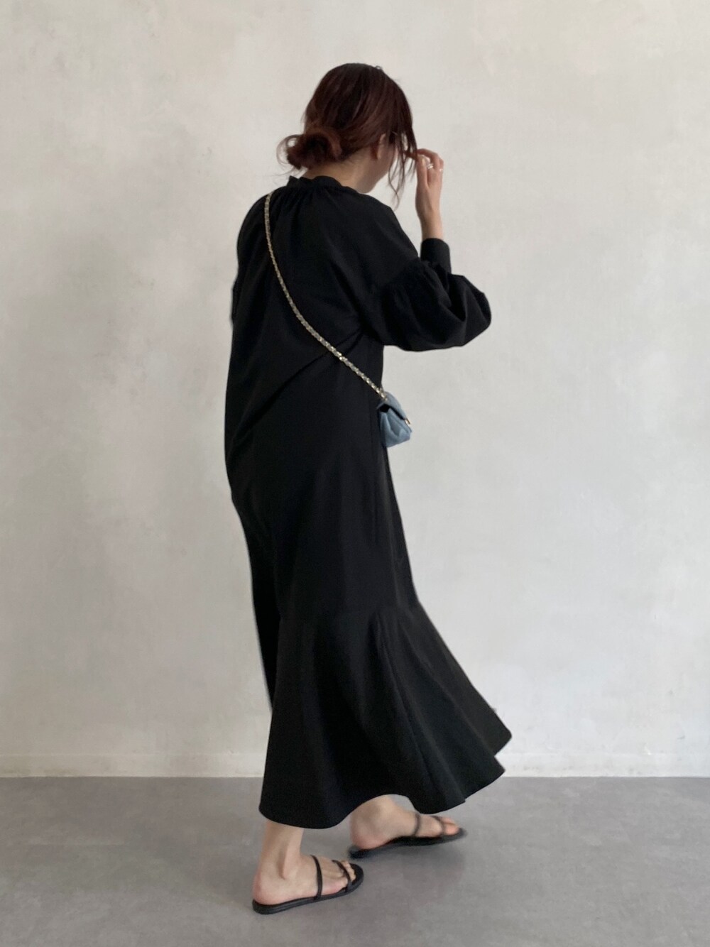 ブラック系のワンピース、ブルー系のショルダーバッグ、ゴールド系のメガネを着用したレディースの春コーディネートの3枚目の写真