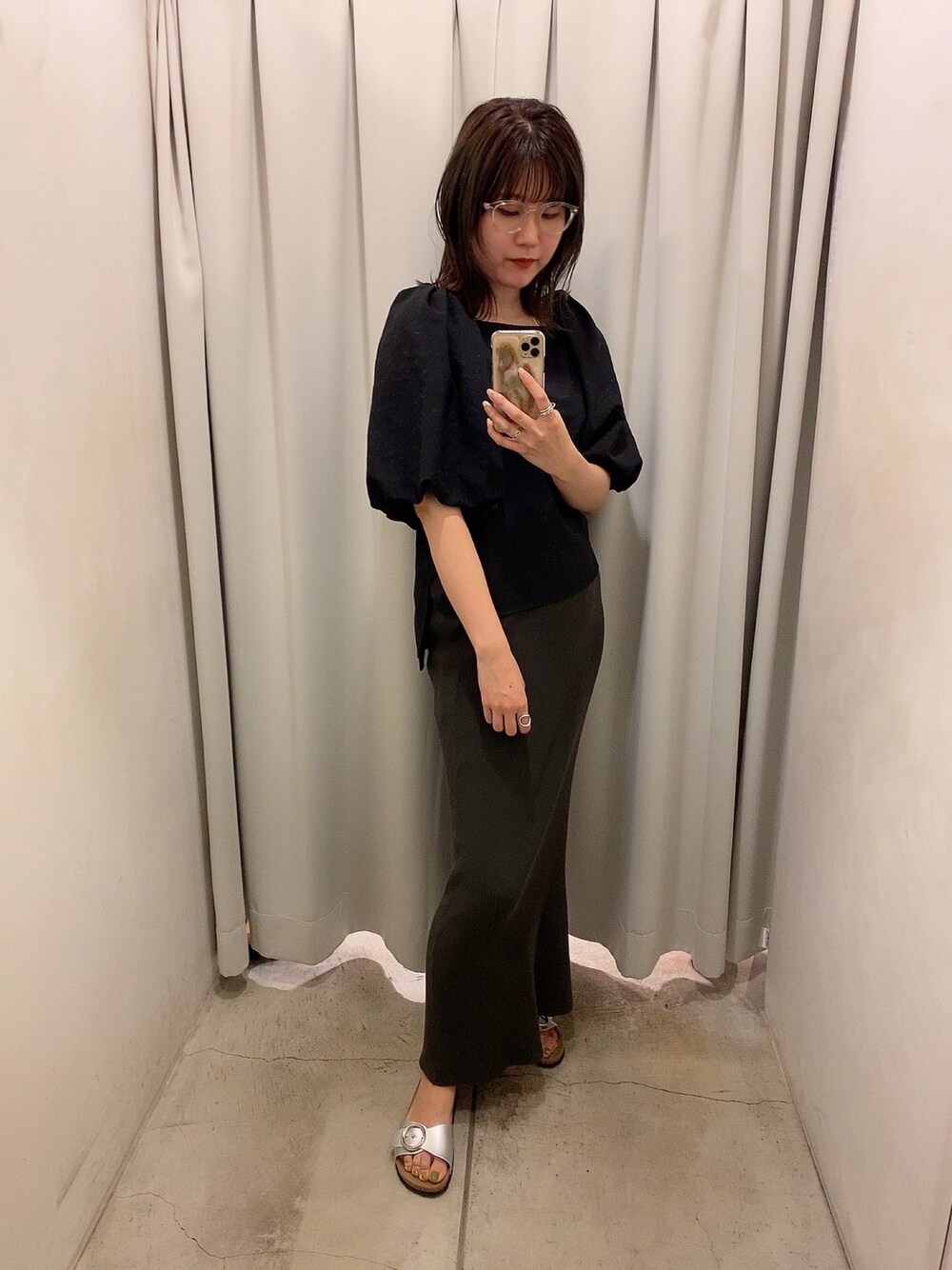 ブラック系のシャツ/ブラウス、グレー系のスカート、シルバー系のシューズを着用したレディースの夏コーディネートの1枚目の写真