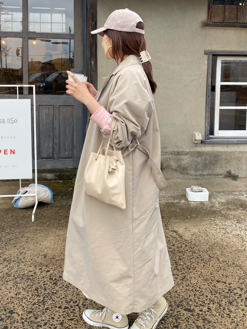 ベージュ系のステンカラーコート、ピンク系のTシャツ/カットソーを着用したレディースの春コーディネートの2枚目の写真