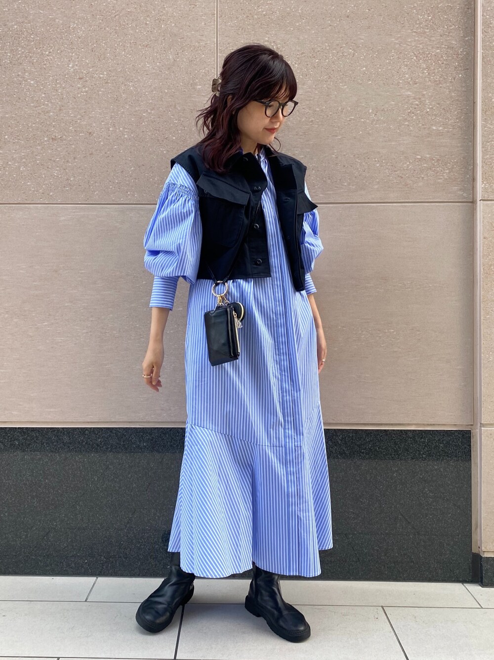 その他のベスト、ブルー系のワンピース、ブラック系のショルダーバッグを着用したレディースの冬コーディネートの2枚目の写真