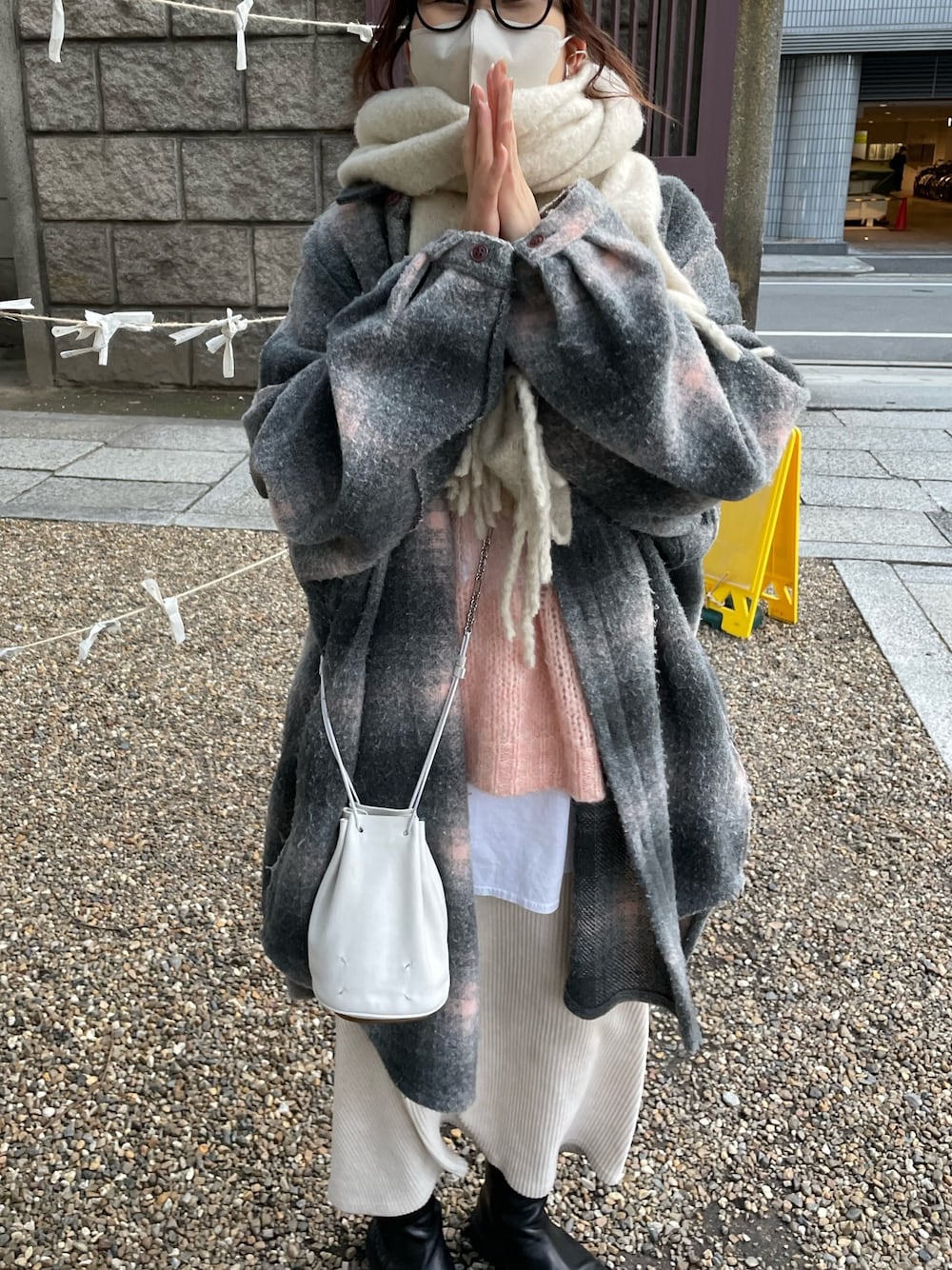 ピンク系のニット/セーター、ホワイト系のスカート、ブラック系のブーツを着用したレディースの冬コーディネートの2枚目の写真