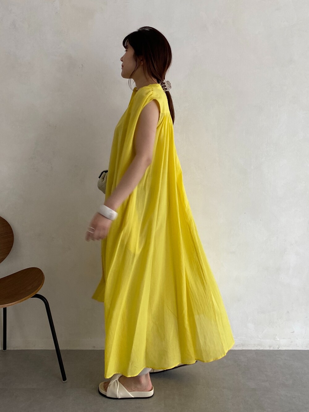 イエロー系のワンピース、ホワイト系のショルダーバッグ、ホワイト系のその他シューズを着用したレディースの春コーディネートの5枚目の写真