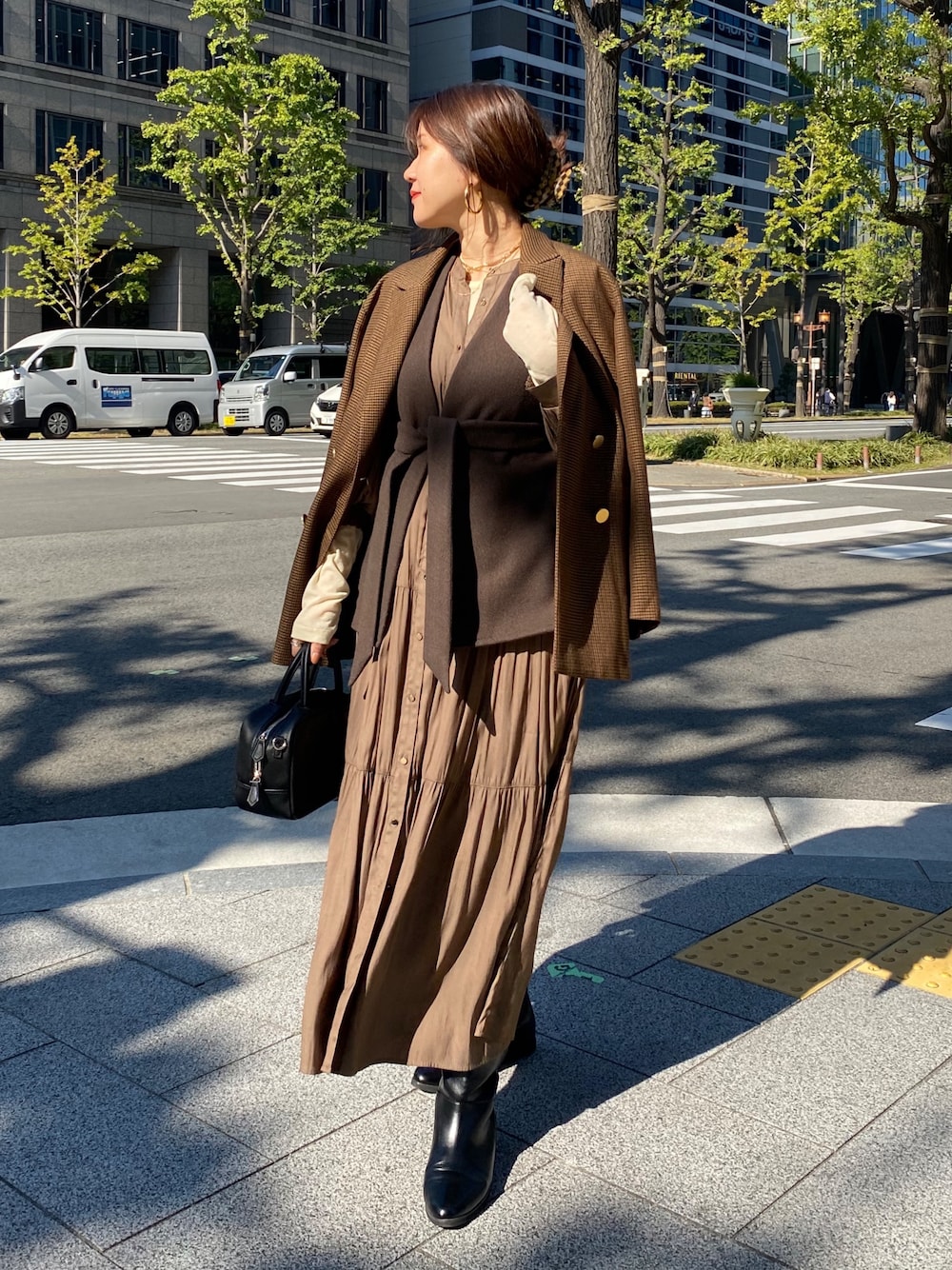 ブラウン系のベスト、ブラウン系のテーラードジャケット、ブラウン系のワンピースを着用したレディースの冬コーディネートの1枚目の写真