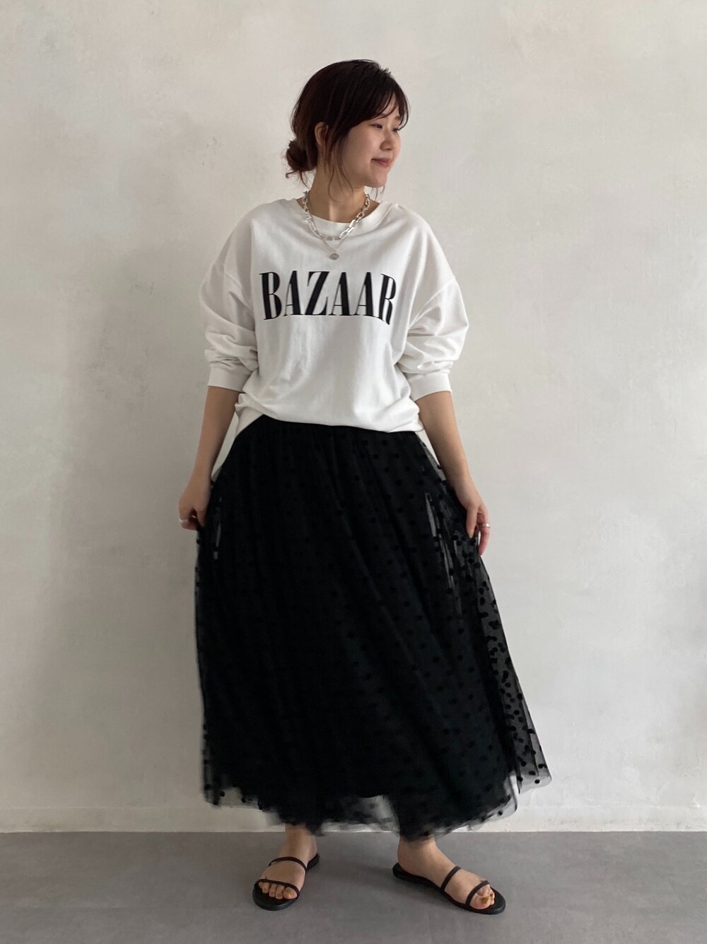 ホワイト系のTシャツ/カットソー、ブラック系のスカート、ブラック系のサンダルを着用したレディースの春コーディネートの2枚目の写真