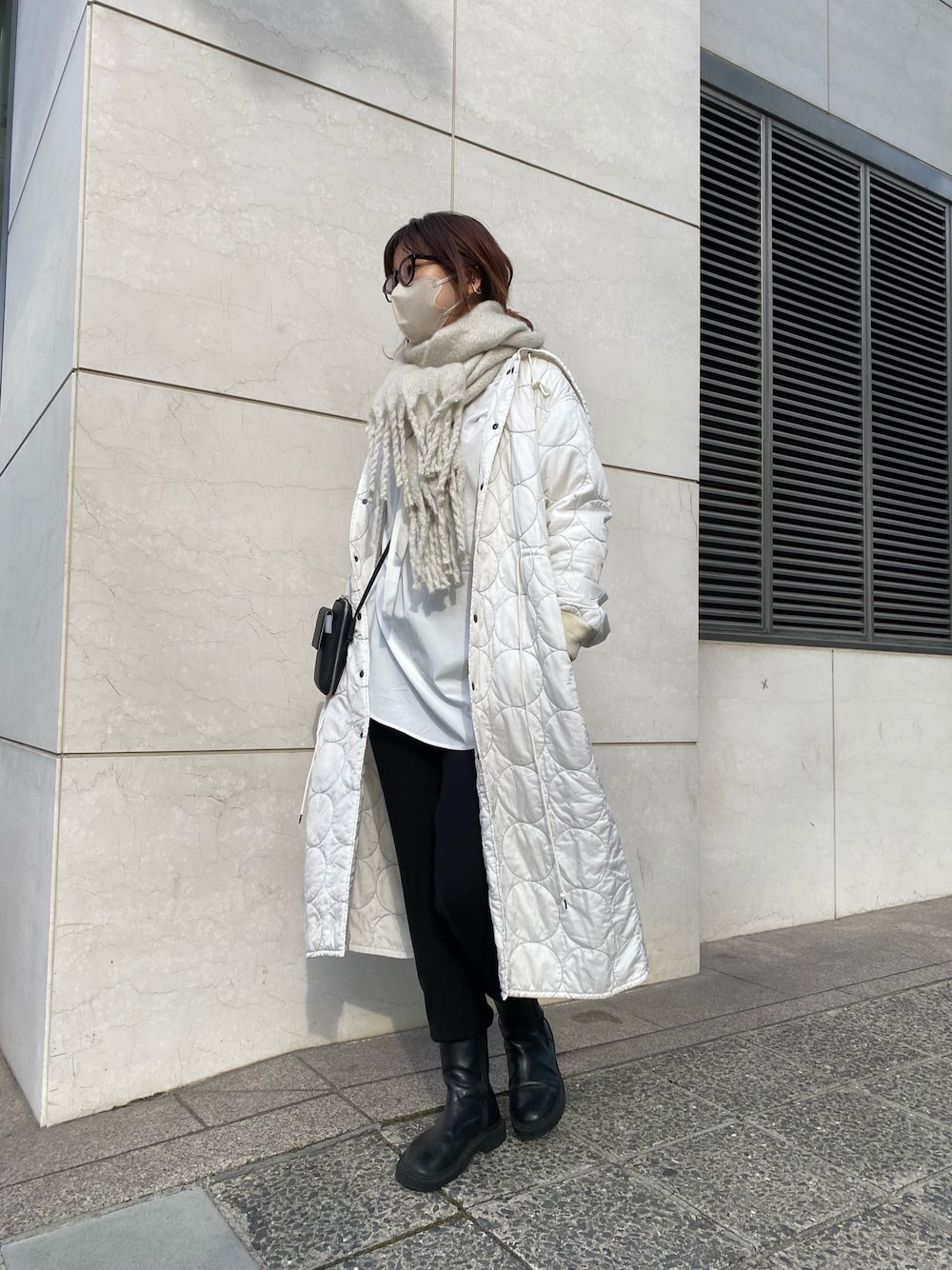 ホワイト系のジャケット/アウター、ブラック系のブーツ、ブラック系のショルダーバッグを着用したレディースの冬コーディネートの2枚目の写真