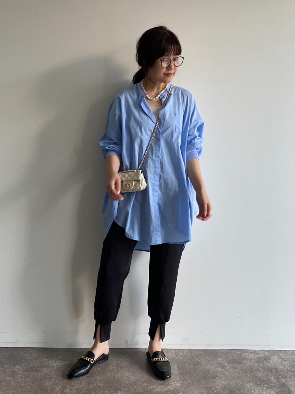 ホワイト系のショルダーバッグ、ブルー系のシャツ/ブラウス、ブラック系のその他パンツを着用したレディースの春コーディネートの2枚目の写真