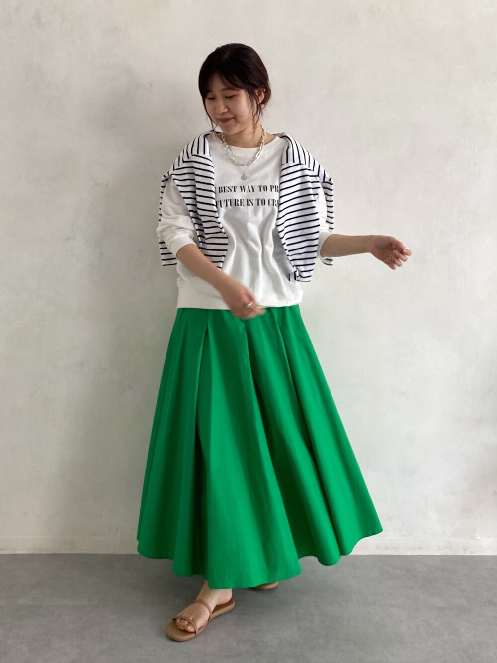 ホワイト系のTシャツ/カットソー、ホワイト系のTシャツ/カットソー、グリーン系のスカートを着用したレディースの春コーディネートの4枚目の写真