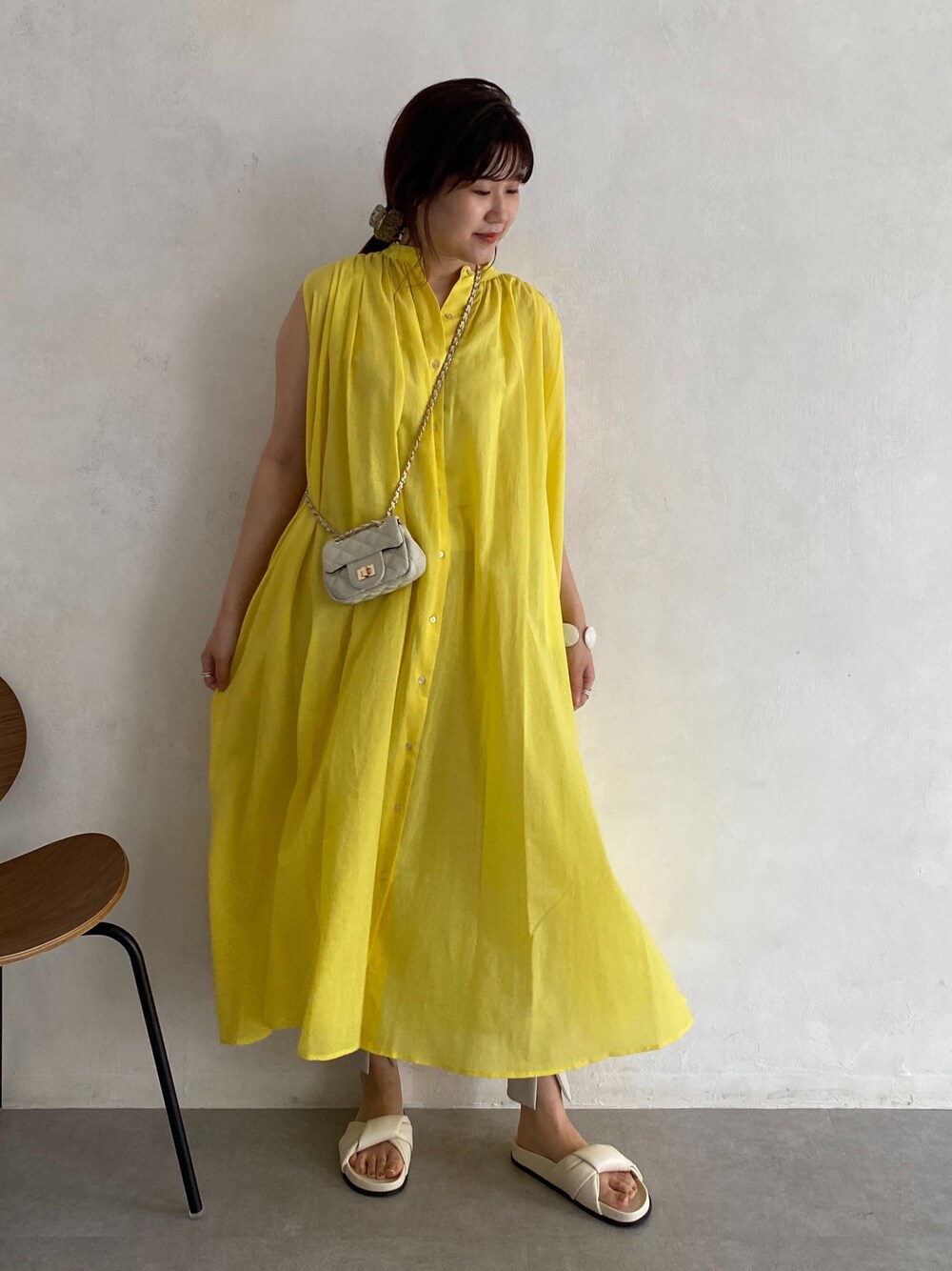 イエロー系のワンピース、ホワイト系のショルダーバッグ、ホワイト系のその他シューズを着用したレディースの春コーディネートの2枚目の写真