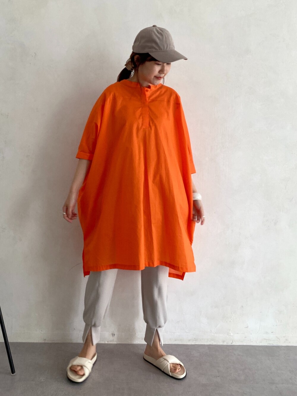 オレンジ系のシャツ/ブラウス、ベージュ系のその他パンツ、ホワイト系のその他シューズを着用したレディースの春コーディネートの3枚目の写真