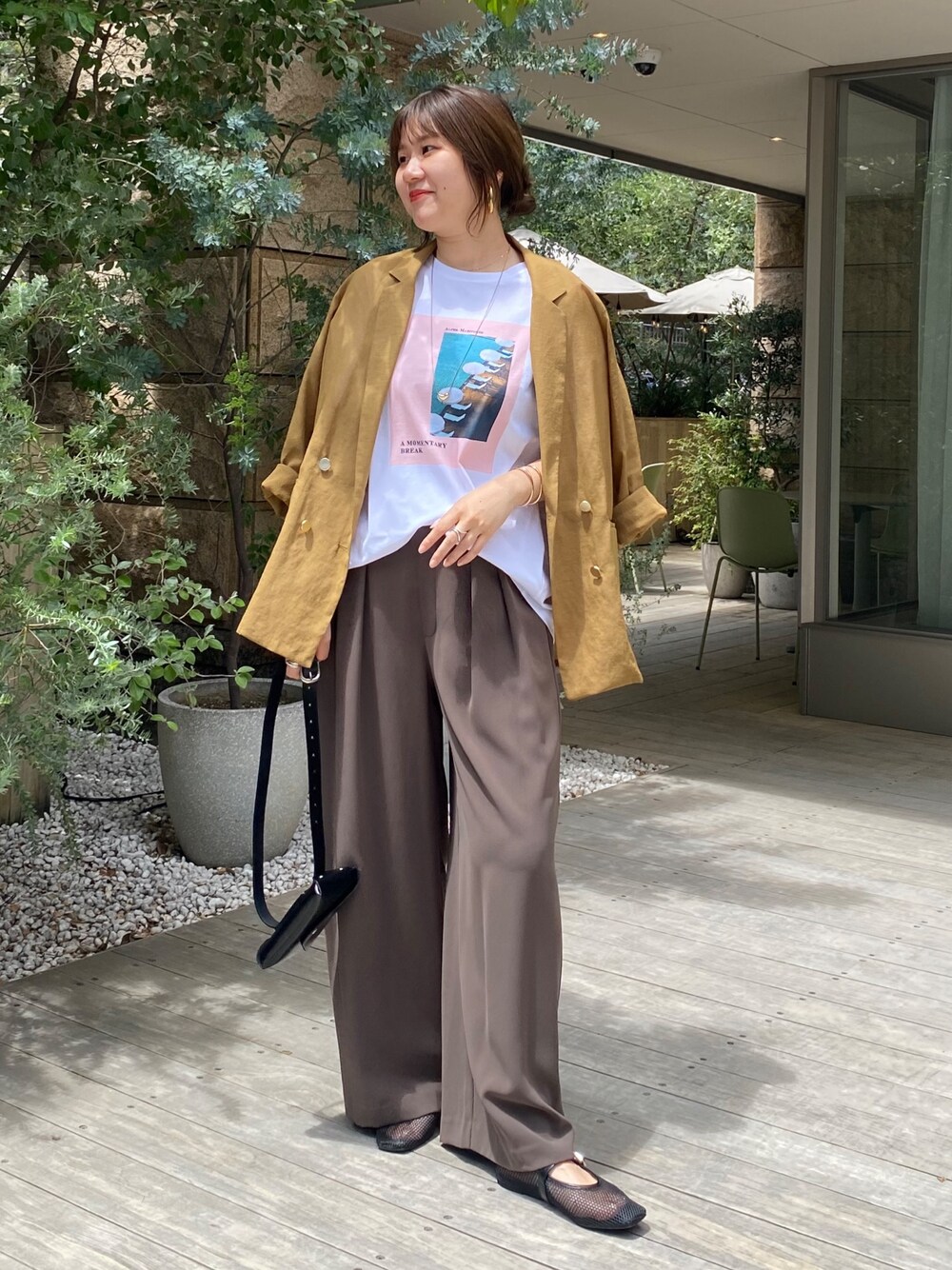イエロー系のテーラードジャケット、ホワイト系のTシャツ/カットソー、ブラウン系のスラックスを着用したレディースの夏コーディネートの1枚目の写真