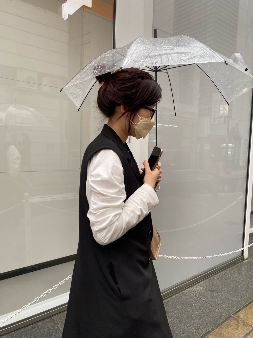 ブラック系のベスト、ホワイト系のTシャツ/カットソー、ベージュ系のスカートを着用したレディースの冬コーディネートの4枚目の写真