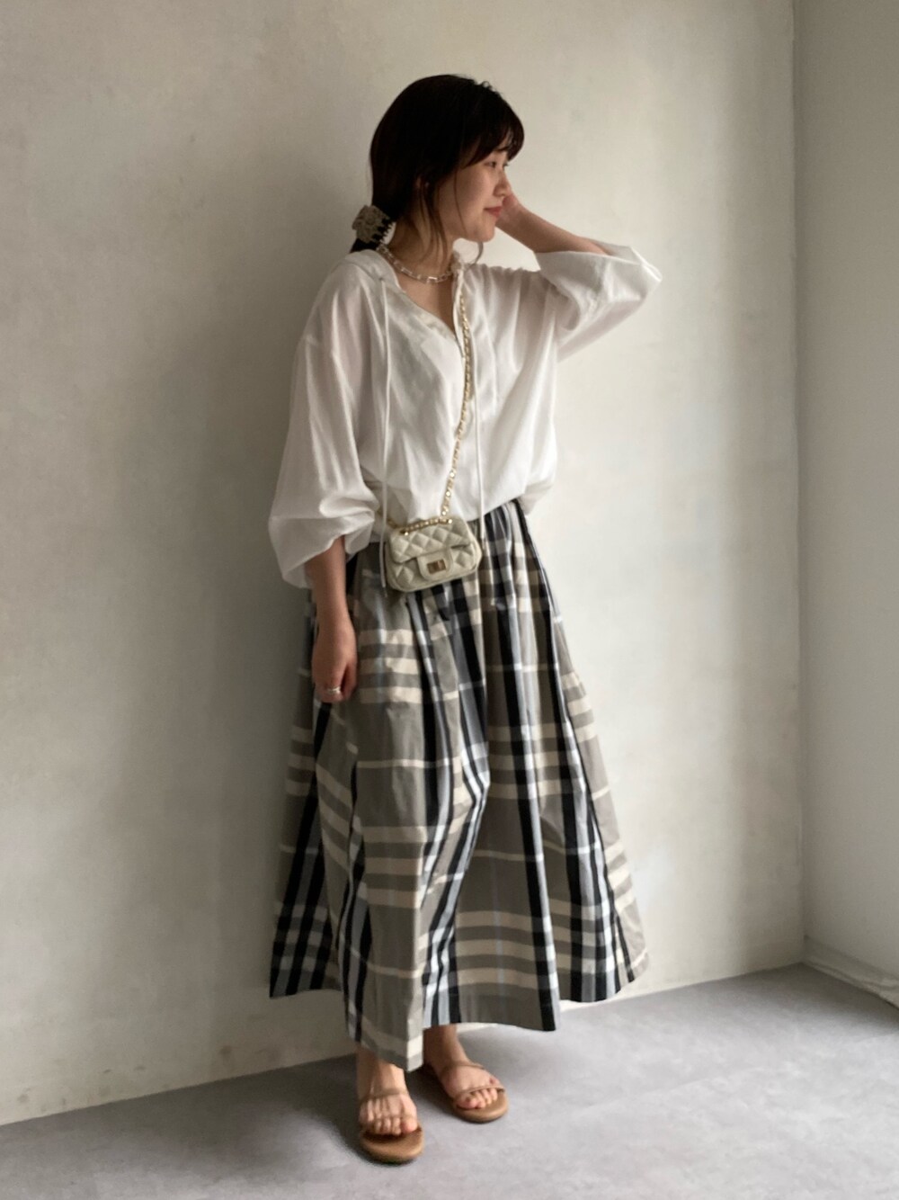 ホワイト系のシャツ/ブラウス、ベージュ系のスカート、ホワイト系のショルダーバッグを着用したレディースの春コーディネートの2枚目の写真