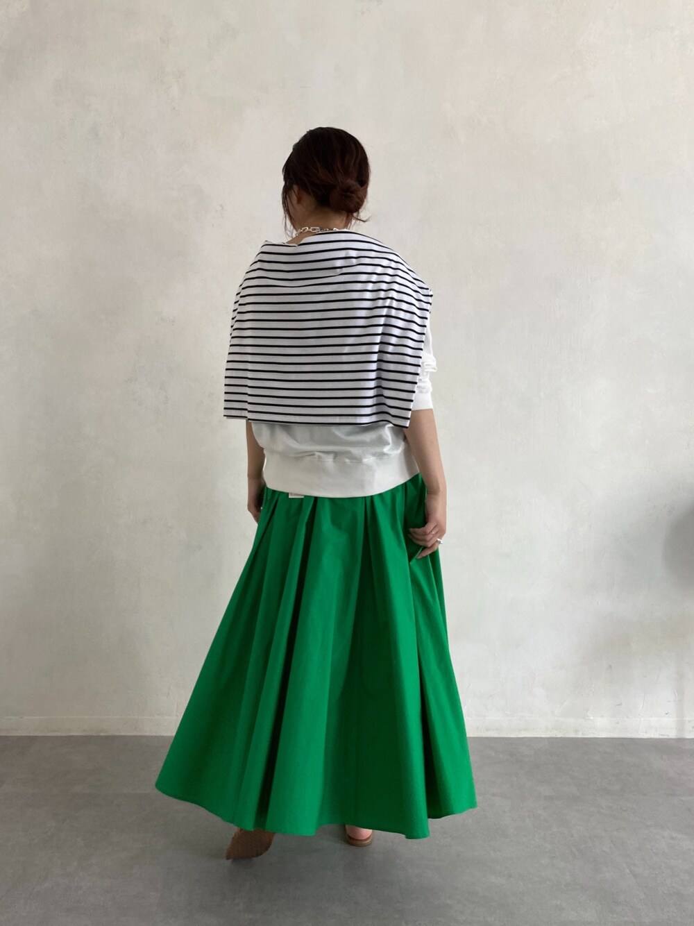 ホワイト系のTシャツ/カットソー、ホワイト系のTシャツ/カットソー、グリーン系のスカートを着用したレディースの春コーディネートの5枚目の写真
