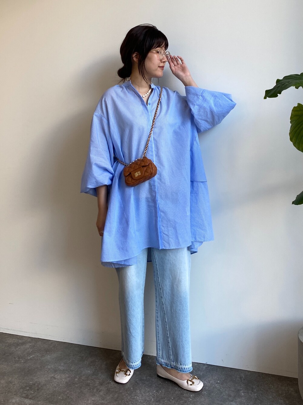 ブルー系のシャツ/ブラウス、ブルー系のデニムパンツ、イエロー系のショルダーバッグを着用したレディースの春コーディネートの2枚目の写真