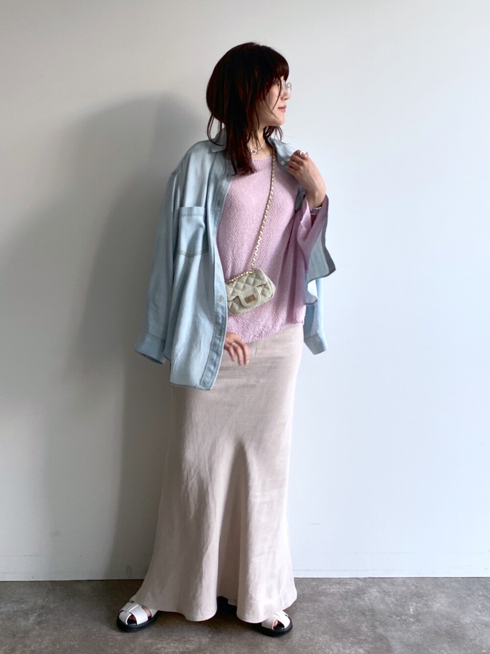 ピンク系のニット/セーター、ブルー系のシャツ/ブラウス、ベージュ系のスカートを着用したレディースの春コーディネートの3枚目の写真