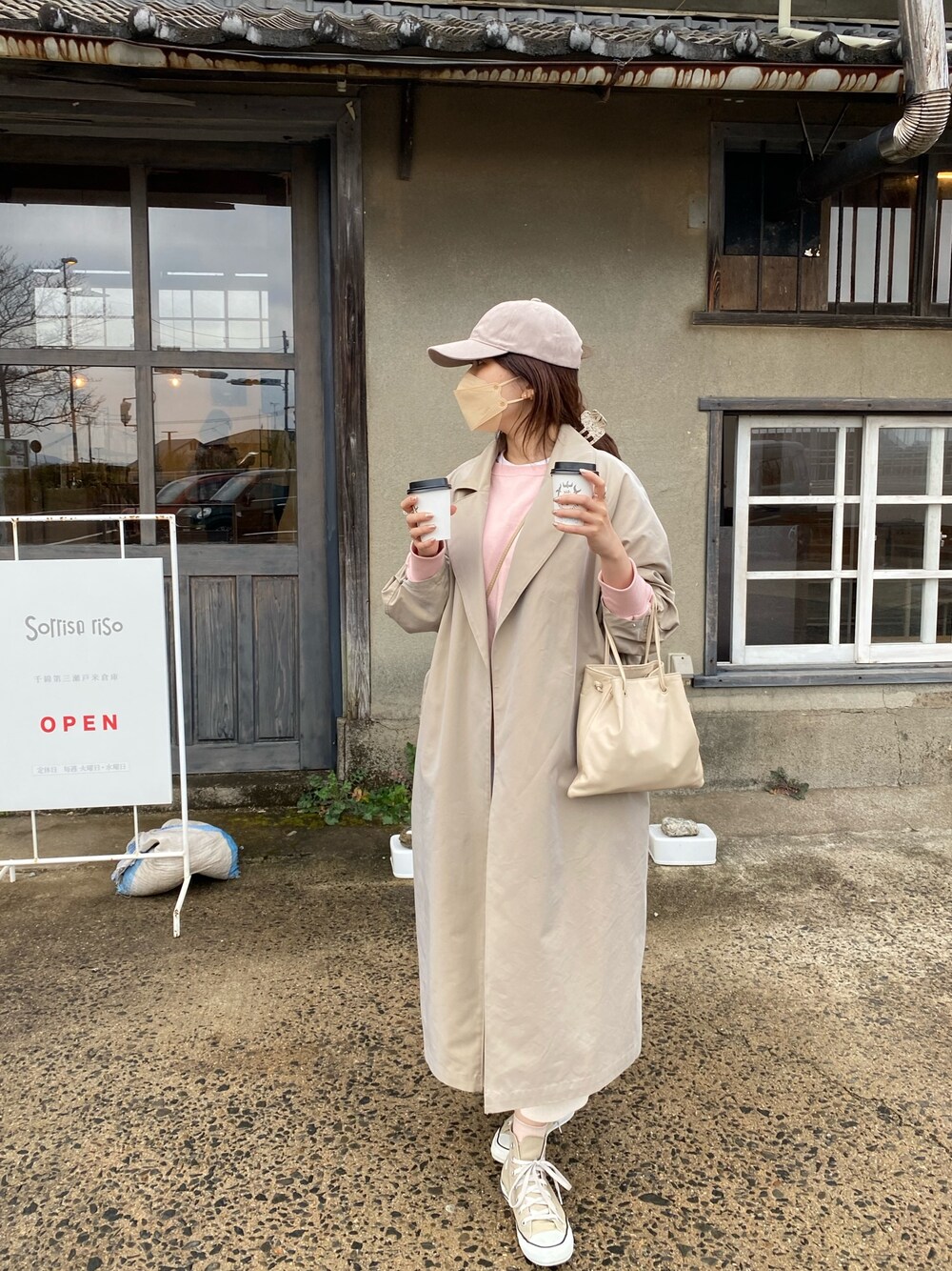 ベージュ系のステンカラーコート、ピンク系のTシャツ/カットソーを着用したレディースの春コーディネートの4枚目の写真