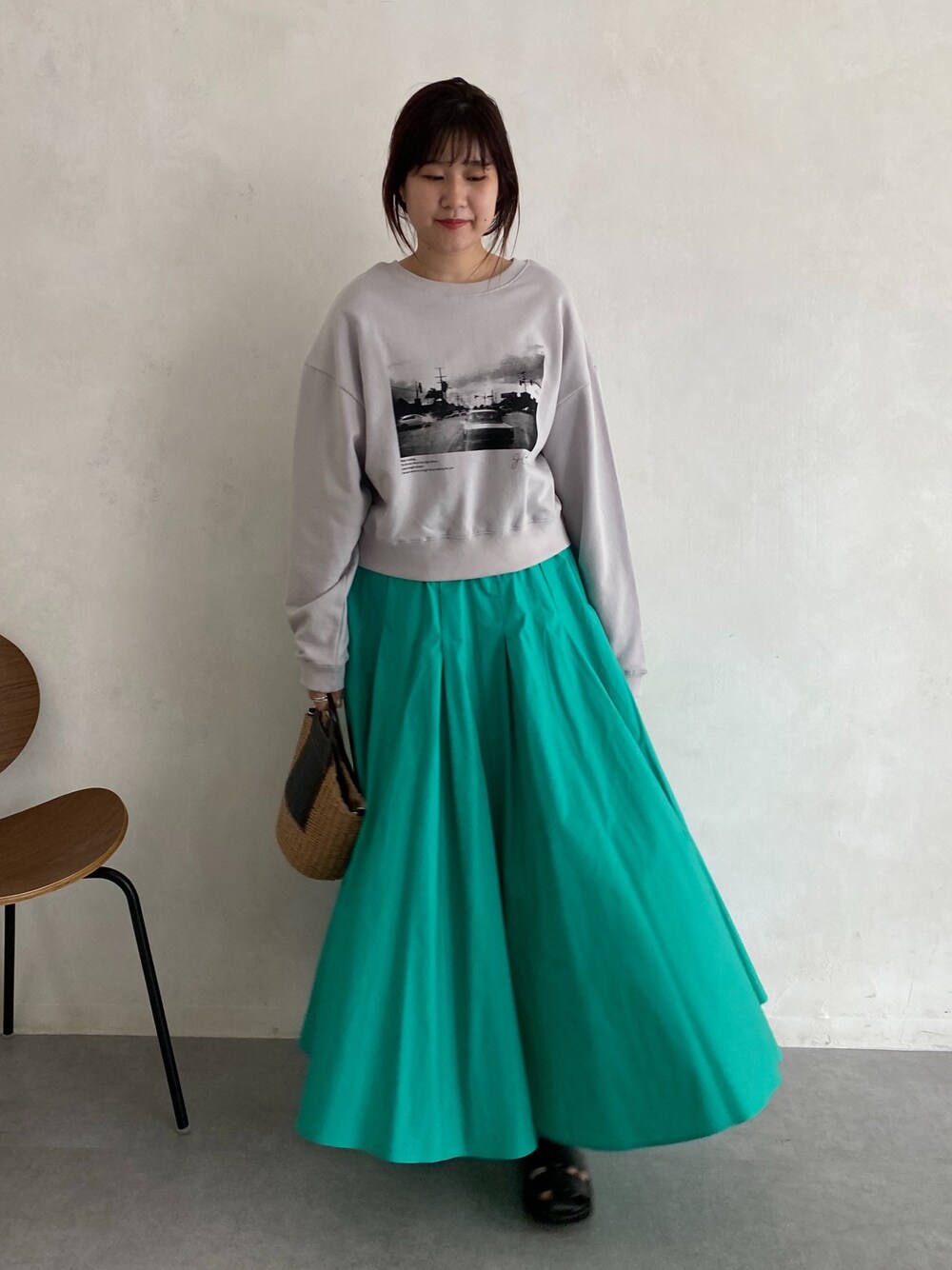 ベージュ系のTシャツ/カットソー、ブルー系のスカート、ブラック系のサンダルを着用したレディースの春コーディネートの4枚目の写真