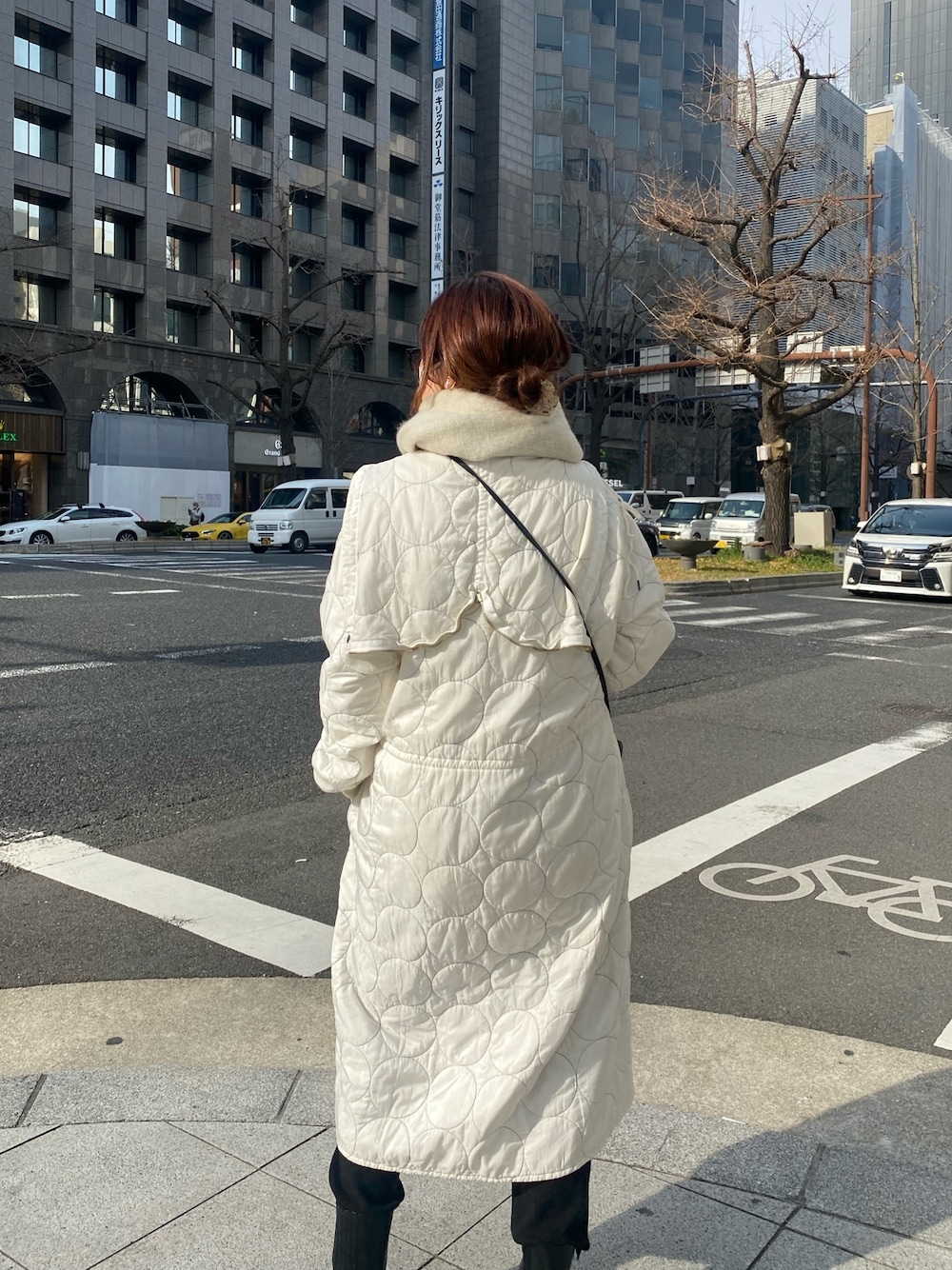 ホワイト系のジャケット/アウター、ブラック系のブーツ、ブラック系のショルダーバッグを着用したレディースの冬コーディネートの5枚目の写真