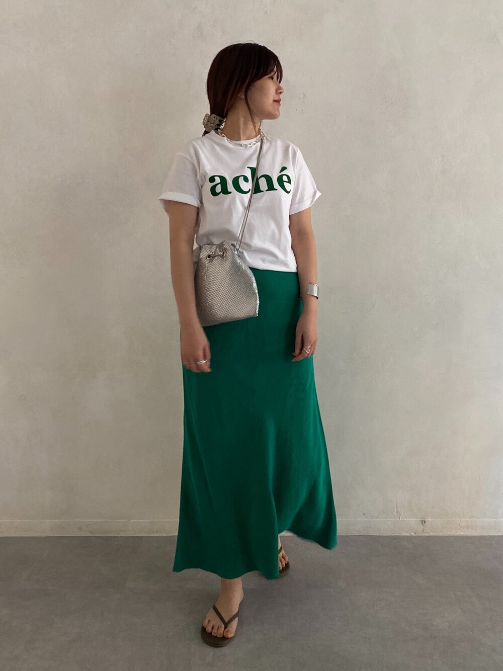ホワイト系のTシャツ/カットソー、シルバー系のトートバッグ、グリーン系のスカートを着用したレディースの春コーディネートの5枚目の写真