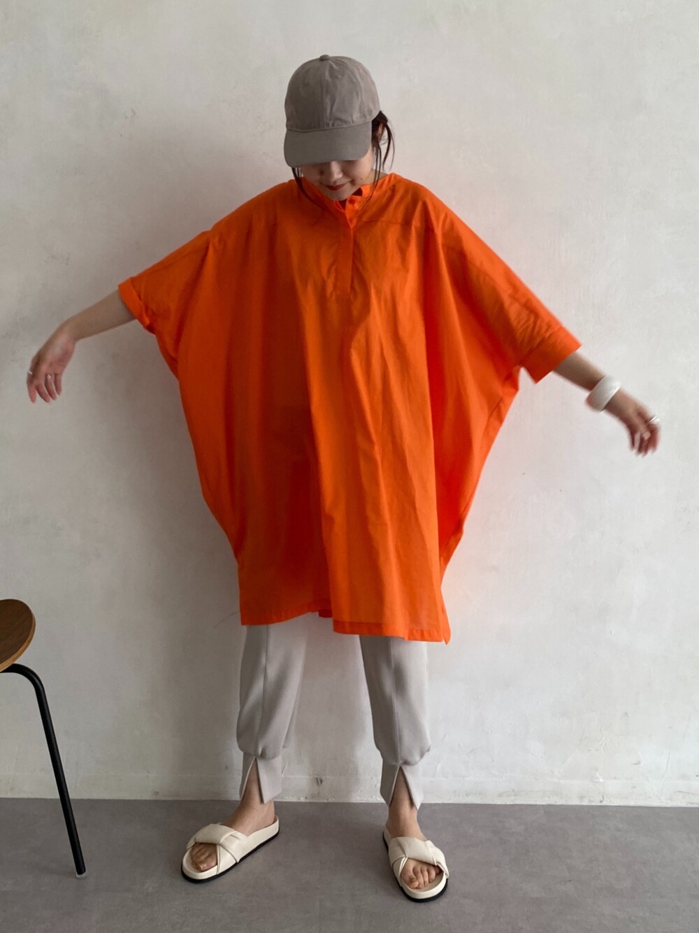 オレンジ系のシャツ/ブラウス、ベージュ系のその他パンツ、ホワイト系のその他シューズを着用したレディースの春コーディネートの2枚目の写真