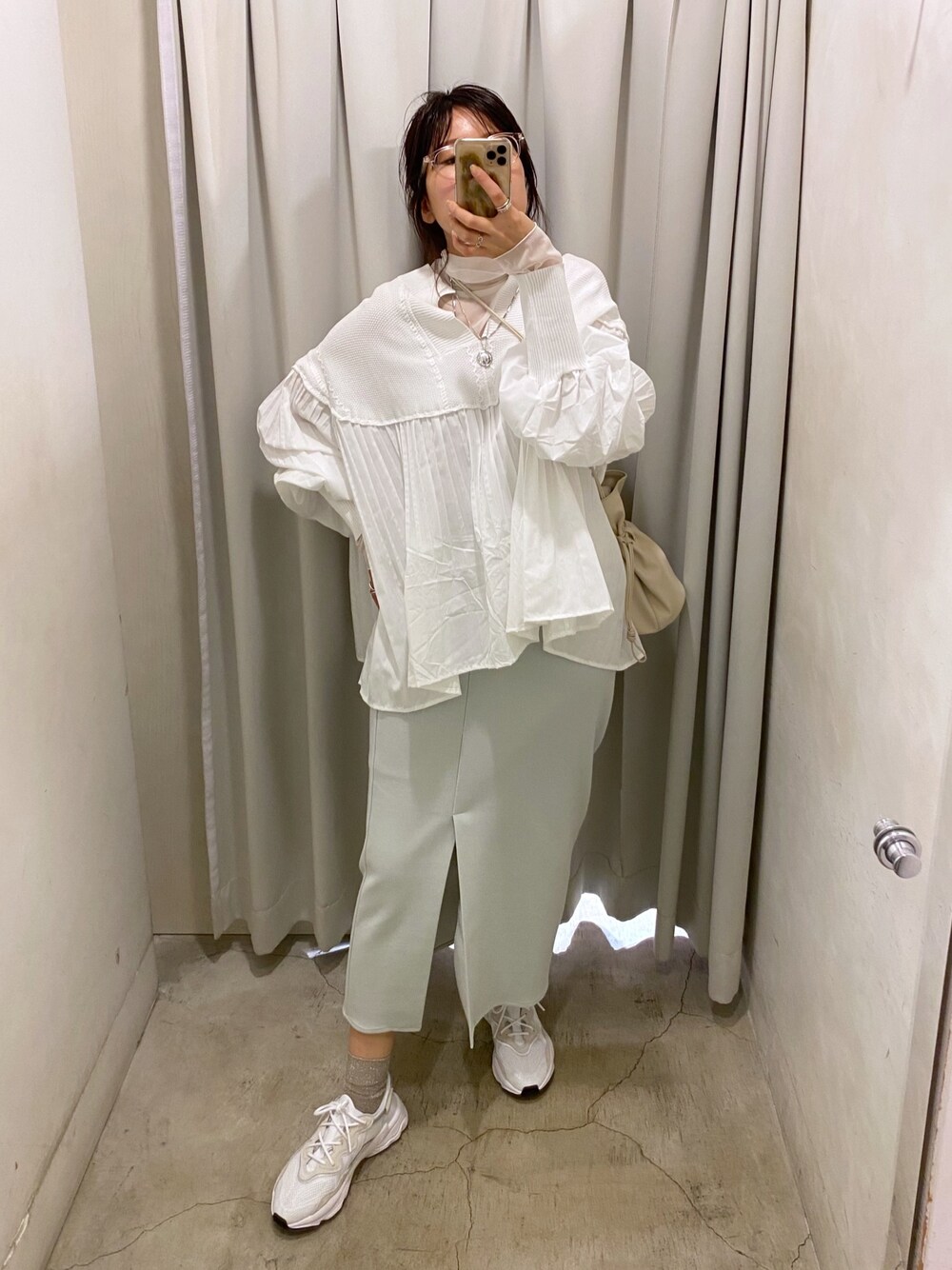 ホワイト系のTシャツ/カットソー、ベージュ系のステンカラーコート、ホワイト系のニット/セーターを着用したレディースの冬コーディネートの2枚目の写真