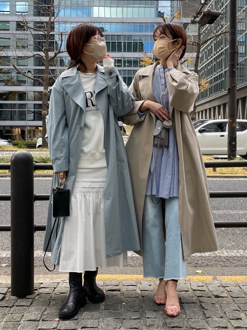 ブルー系のトレンチコート、ベージュ系のステンカラーコート、ホワイト系のTシャツ/カットソーを着用したレディースの冬コーディネートの2枚目の写真