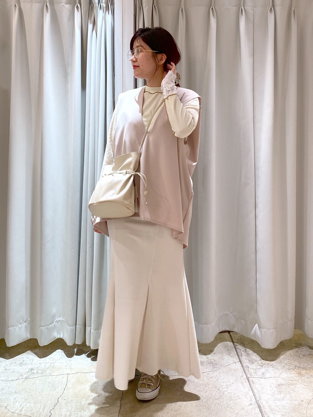 ベージュ系のベスト、ホワイト系のTシャツ/カットソー、ホワイト系のスカートを着用したレディースの春コーディネートの5枚目の写真