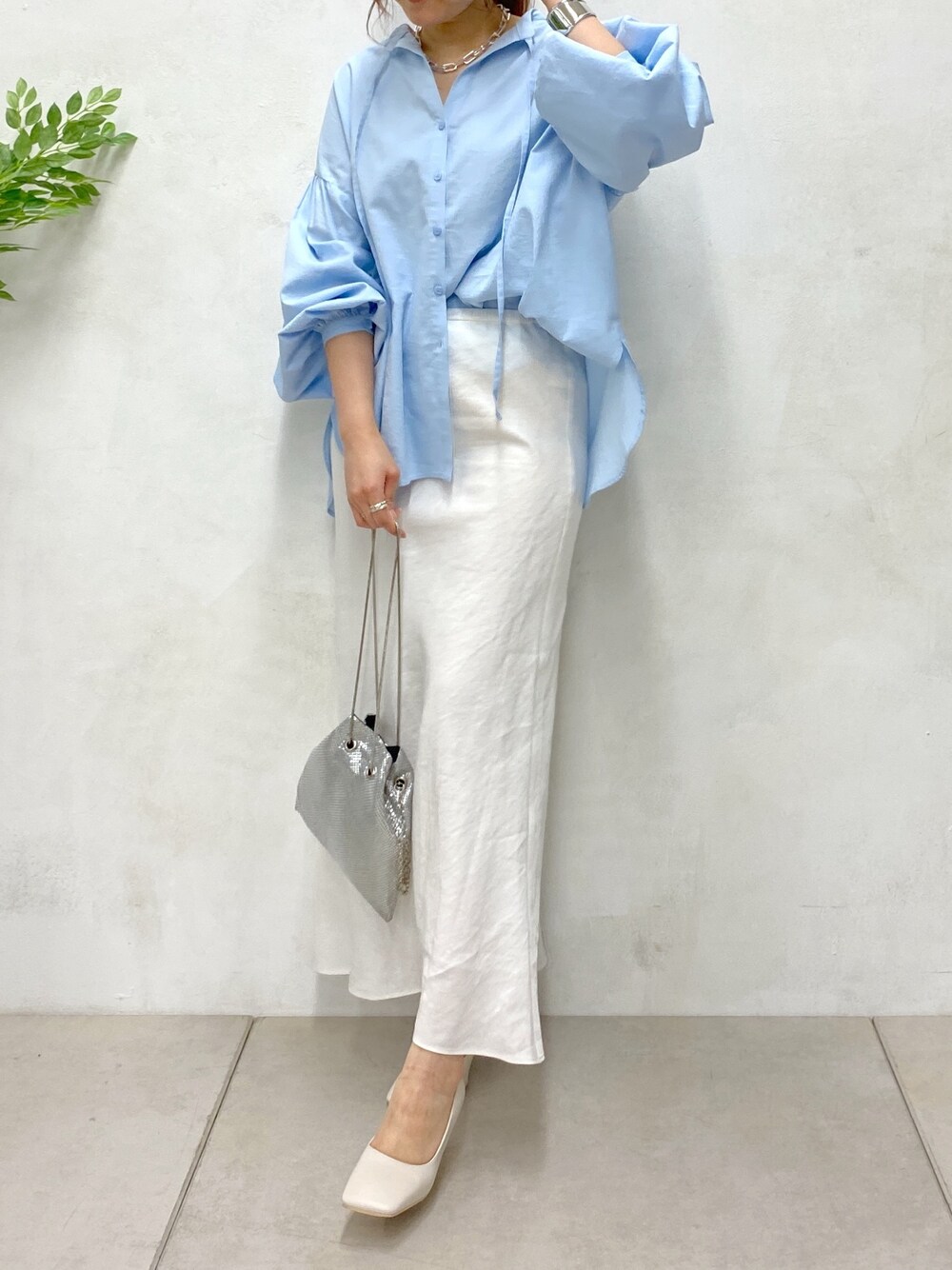 ブルー系のシャツ/ブラウス、ホワイト系のスカート、シルバー系のトートバッグを着用したレディースの春コーディネートの3枚目の写真
