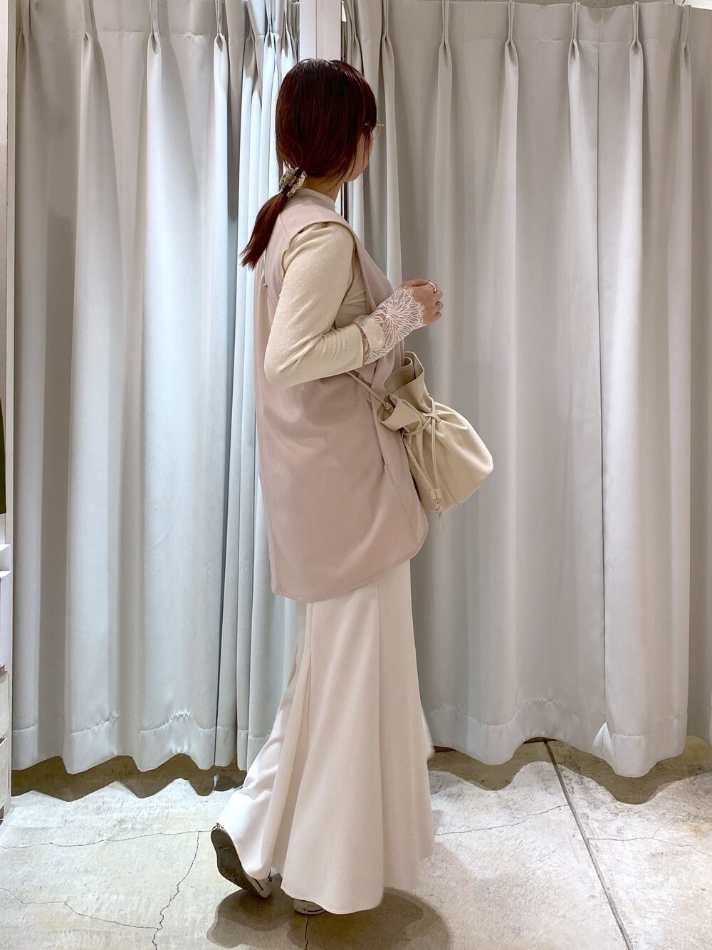 ベージュ系のベスト、ホワイト系のTシャツ/カットソー、ホワイト系のスカートを着用したレディースの春コーディネートの4枚目の写真