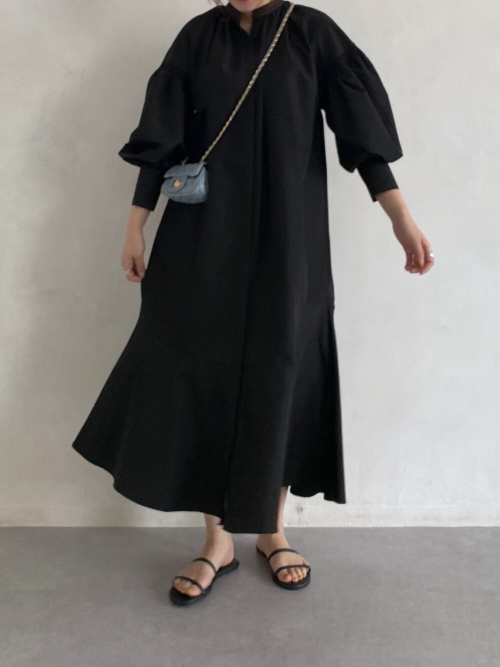 ブラック系のワンピース、ブルー系のショルダーバッグ、ゴールド系のメガネを着用したレディースの春コーディネートの4枚目の写真