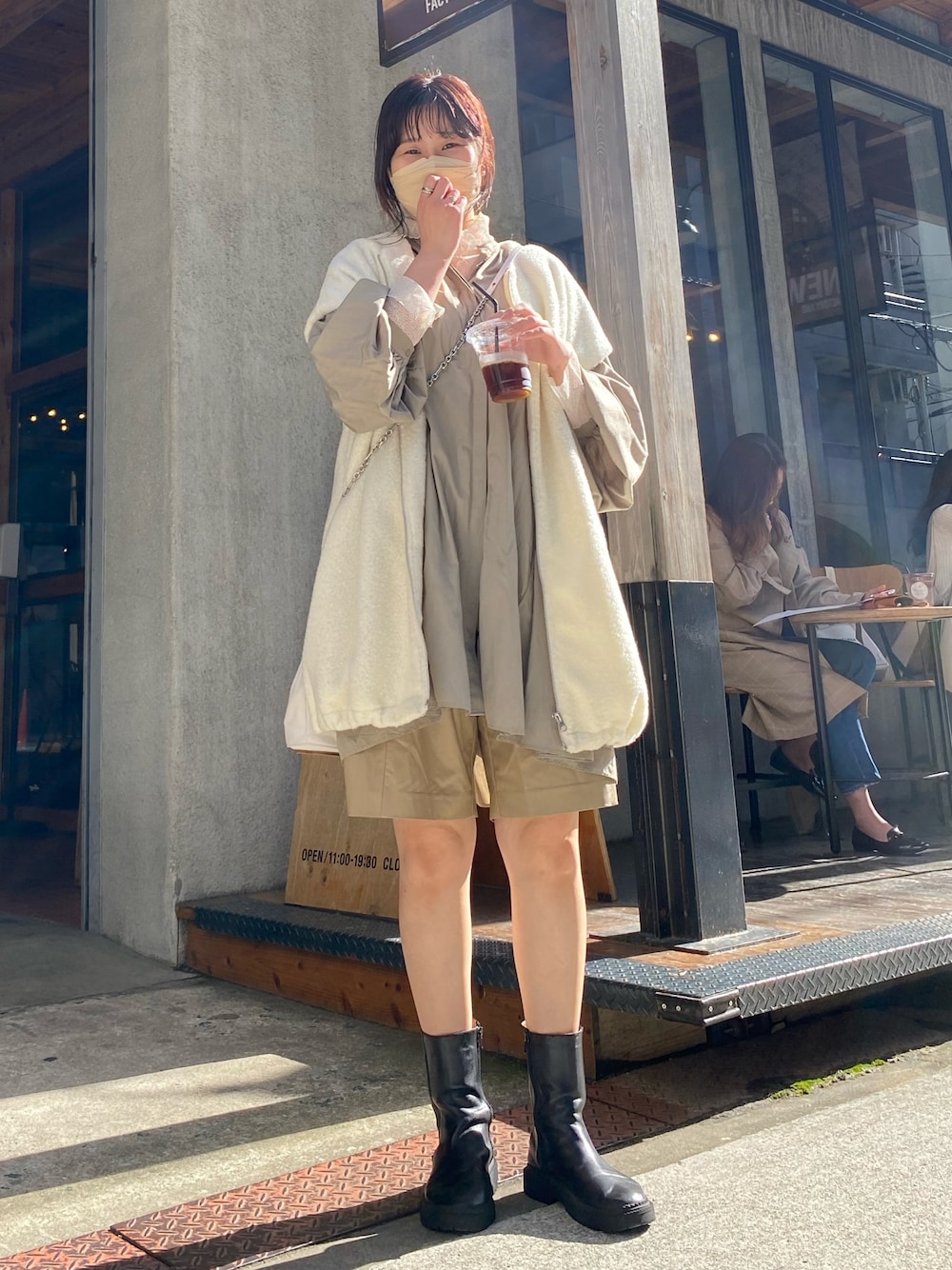 ブラック系のブーツ、ホワイト系のベスト、グリーン系のシャツ/ブラウスを着用したレディースの春コーディネートの2枚目の写真