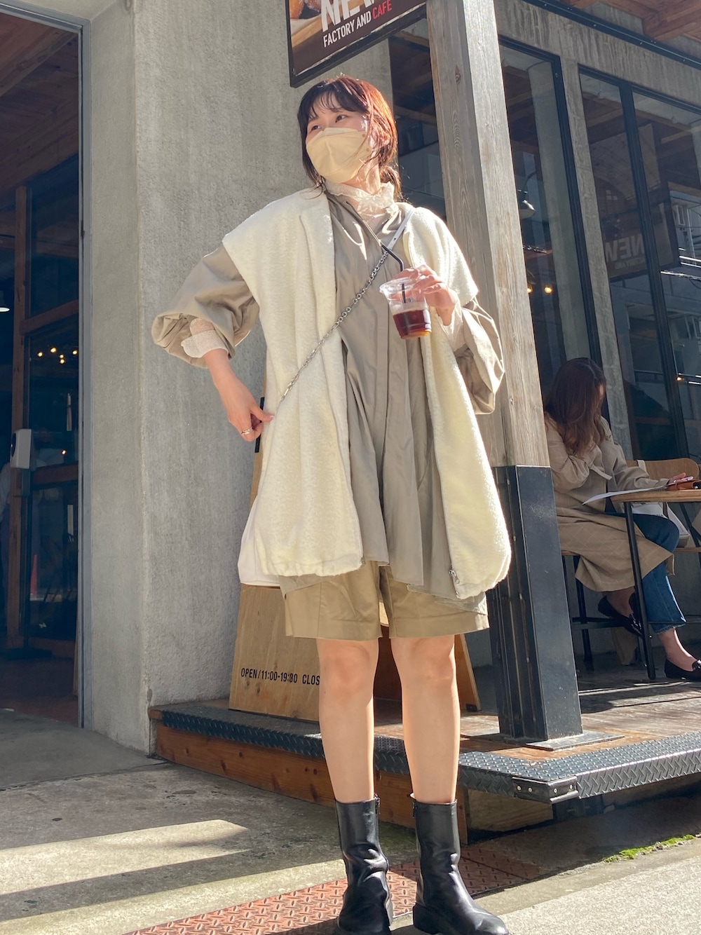 ブラック系のブーツ、ホワイト系のベスト、グリーン系のシャツ/ブラウスを着用したレディースの春コーディネートの4枚目の写真