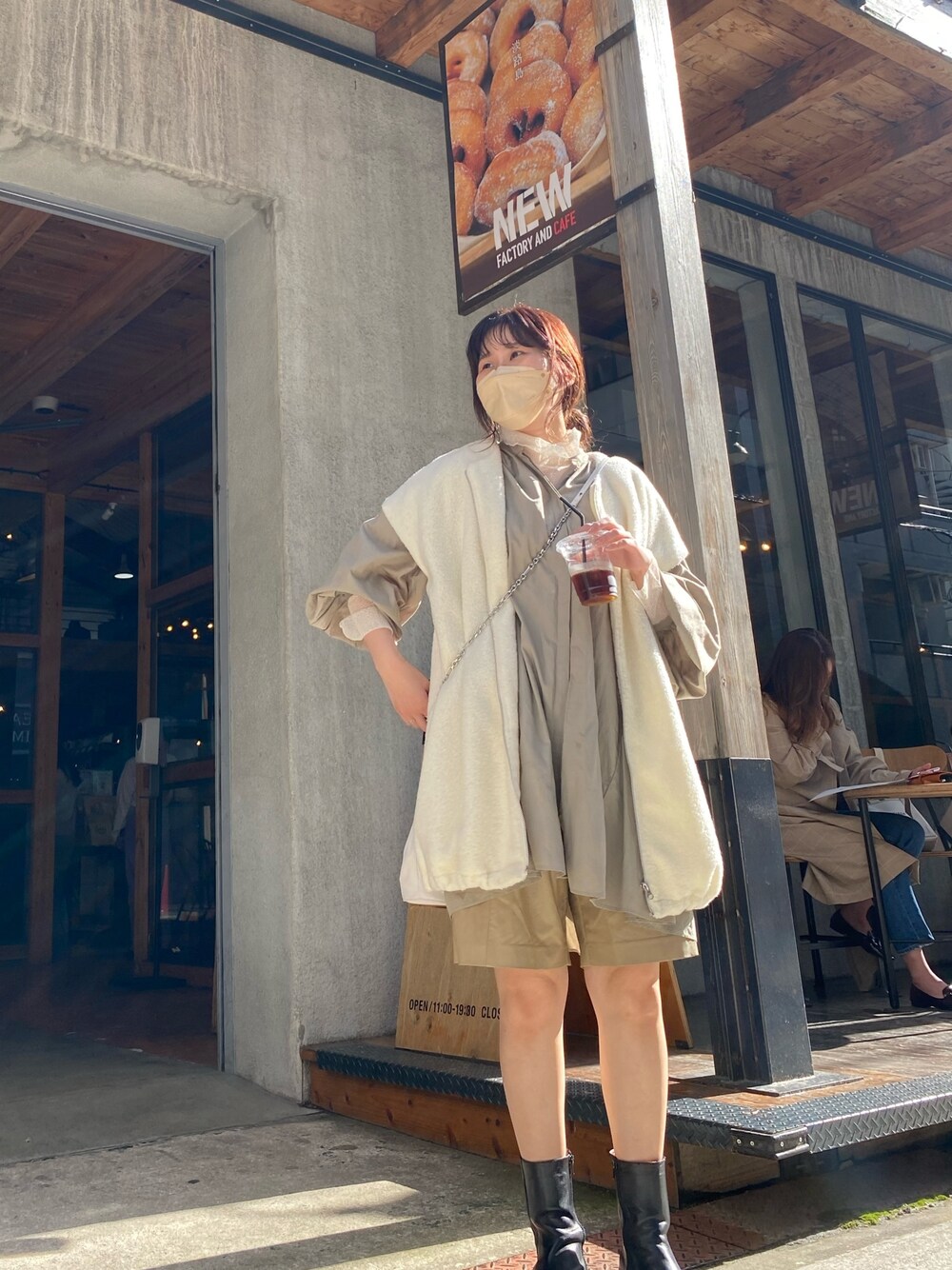 ブラック系のブーツ、ホワイト系のベスト、グリーン系のシャツ/ブラウスを着用したレディースの春コーディネートの3枚目の写真