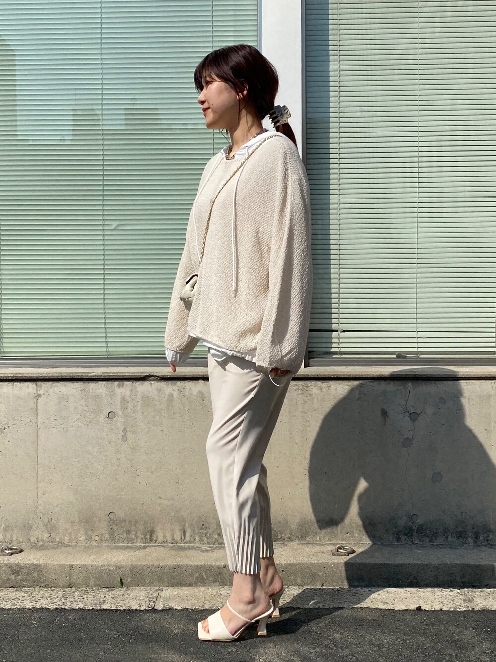 ホワイト系のニット/セーター、ホワイト系のシャツ/ブラウス、ベージュ系のその他パンツを着用したレディースの春コーディネートの4枚目の写真