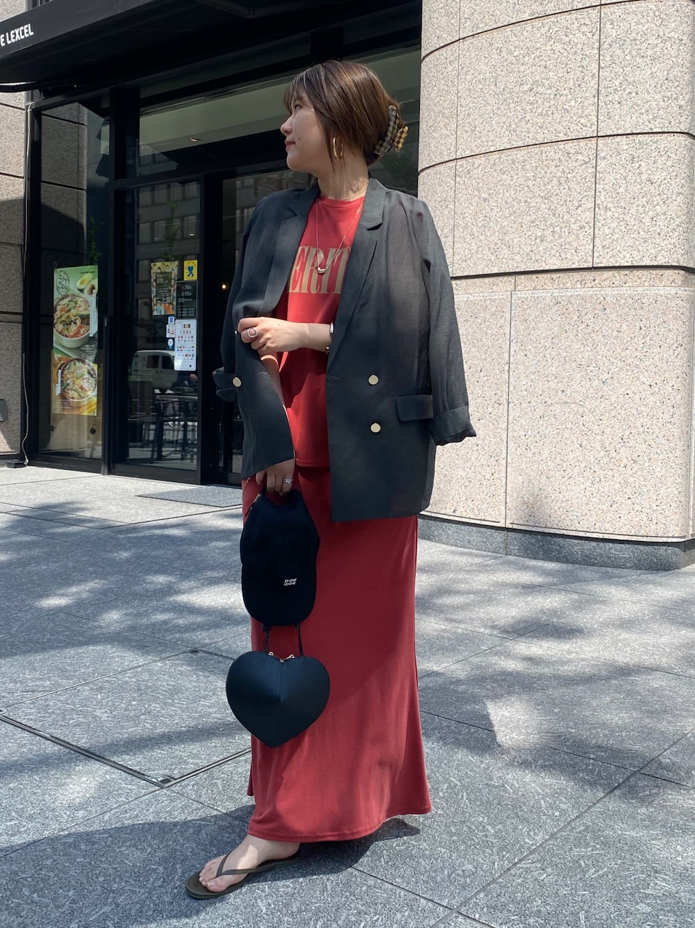 グレー系のテーラードジャケット、レッド系のTシャツ/カットソー、ブラック系のショルダーバッグを着用したレディースの春コーディネートの1枚目の写真