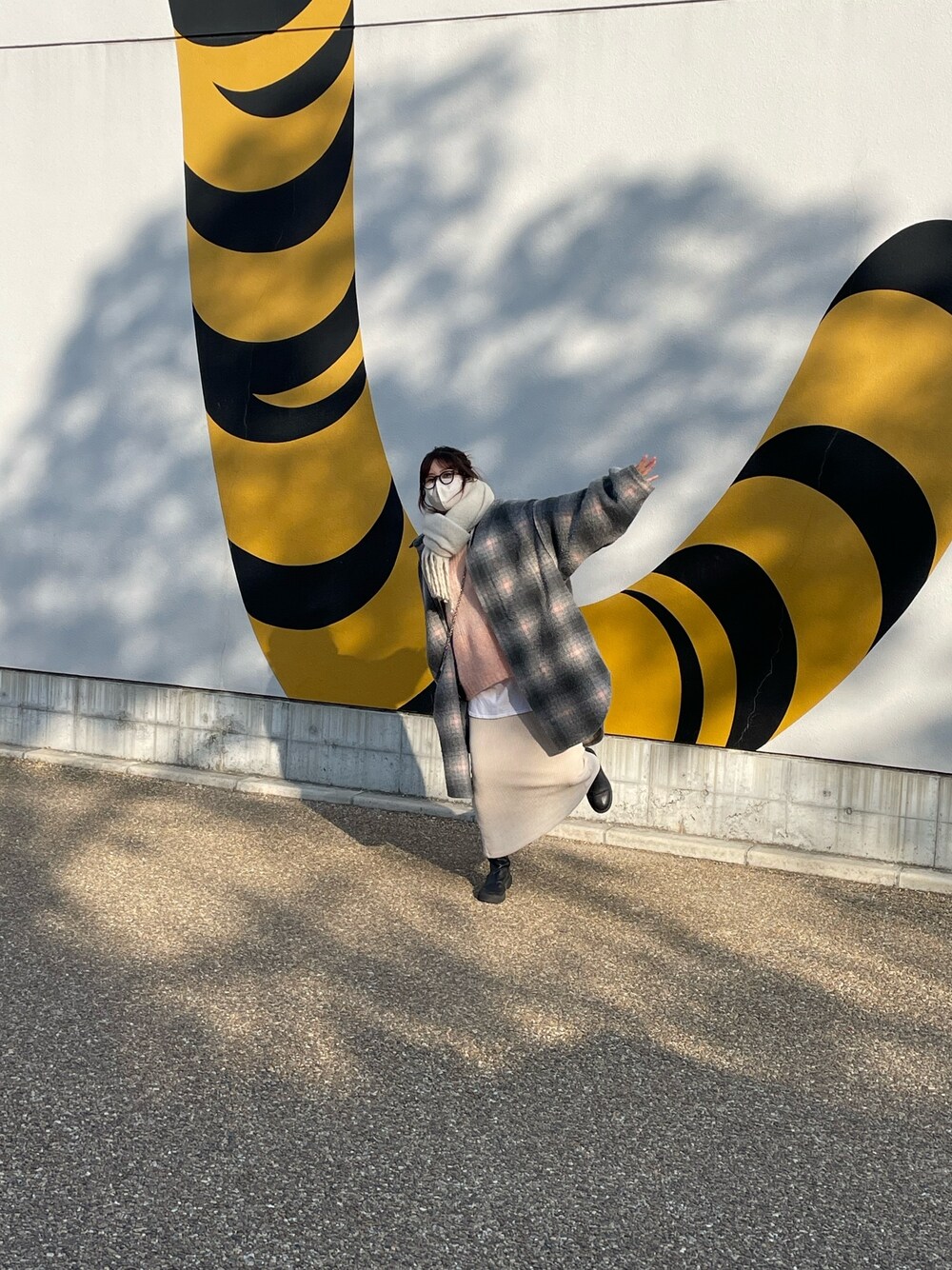 ピンク系のニット/セーター、ホワイト系のスカート、ブラック系のブーツを着用したレディースの冬コーディネートの4枚目の写真