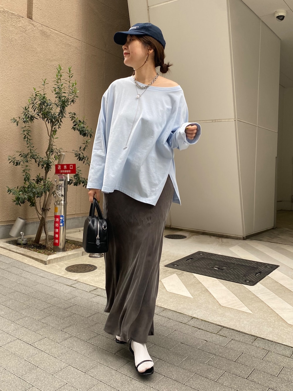 ブルー系のTシャツ/カットソー、ブラック系のスカート、ブラック系のショルダーバッグを着用したレディースの春コーディネートの1枚目の写真