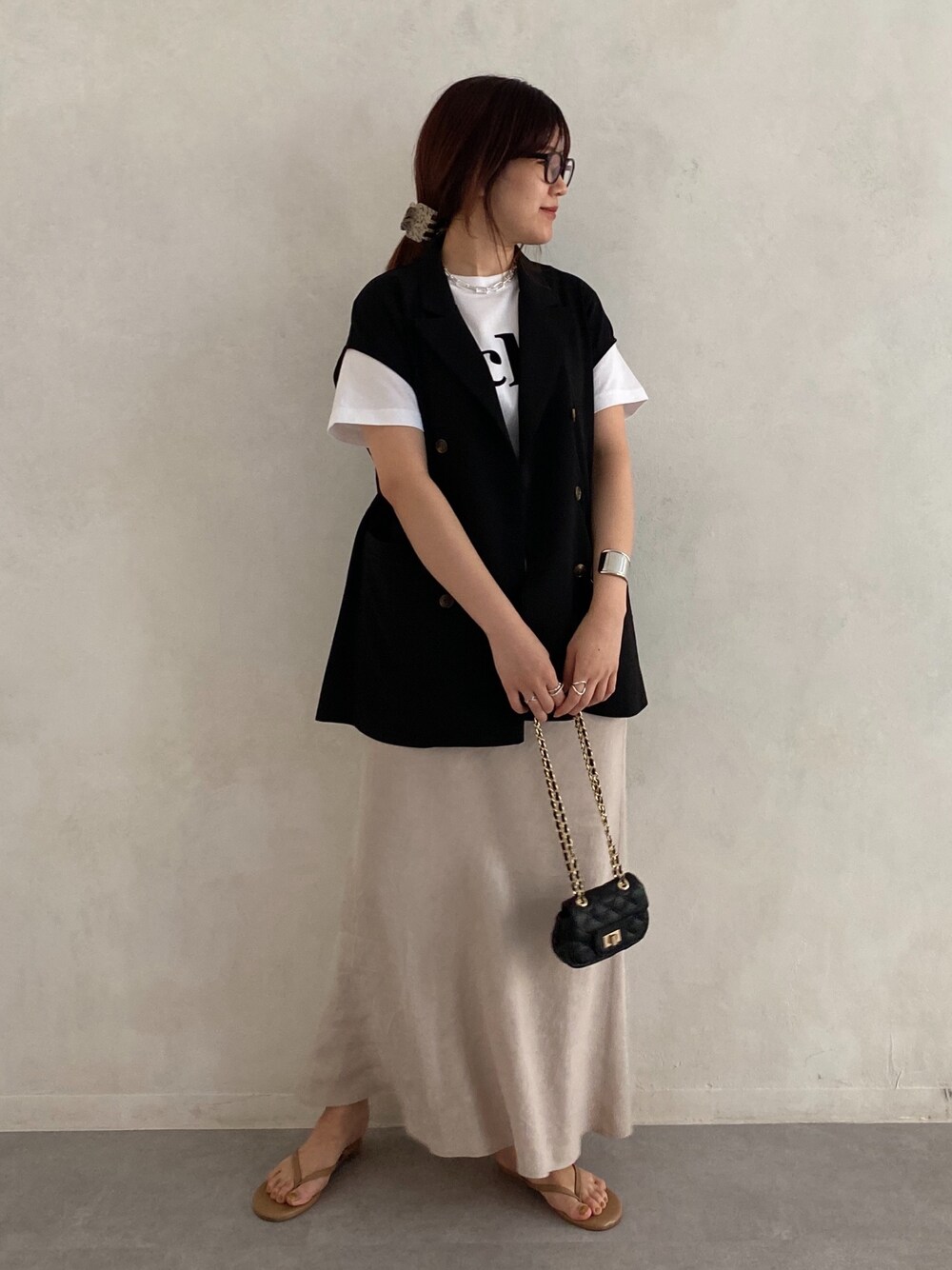 ブラック系のベスト、ホワイト系のTシャツ/カットソー、ブラック系のショルダーバッグを着用したレディースの春コーディネートの2枚目の写真