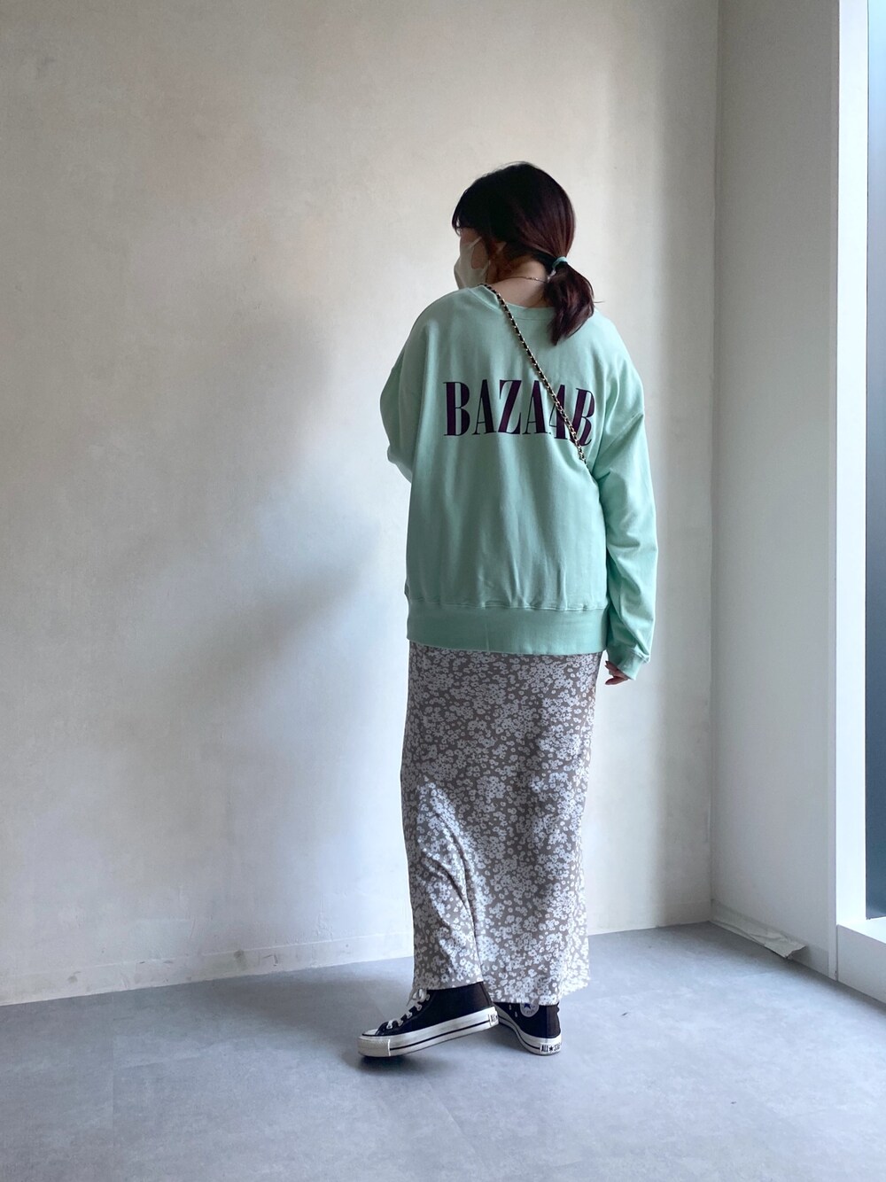 グリーン系のTシャツ/カットソー、ベージュ系のスカート、ブラウン系のスニーカーを着用したレディースの冬コーディネートの3枚目の写真