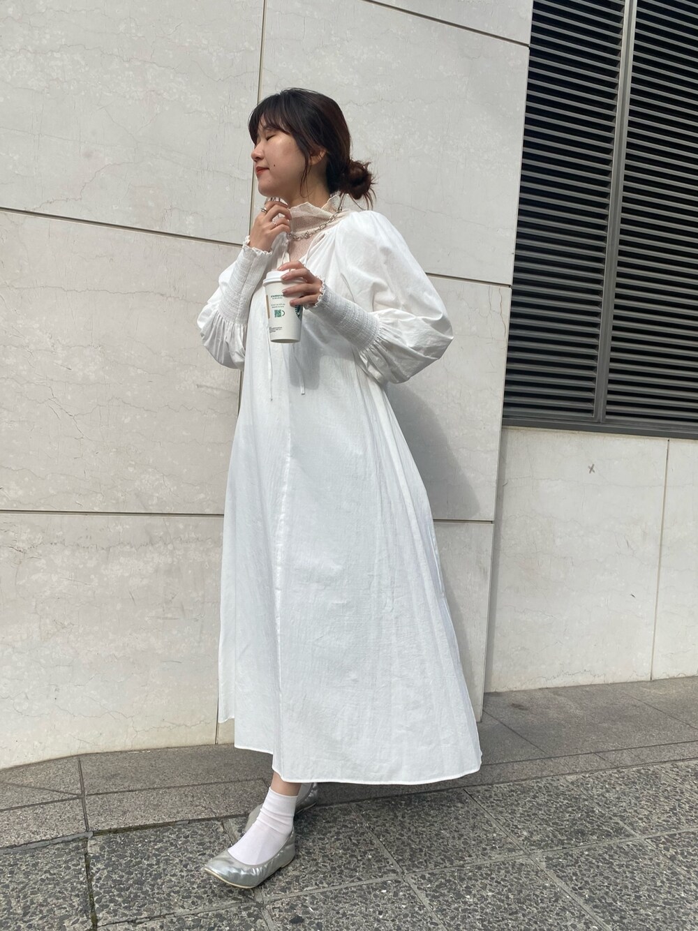 ホワイト系のワンピース、ホワイト系のTシャツ/カットソー、シルバー系のパンプスを着用したレディースの冬コーディネートの4枚目の写真